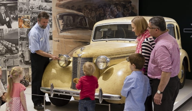 Family listening to a British Motor Museum tour guide